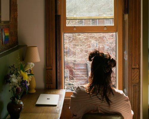 Woman taking a stretch break near her home office window