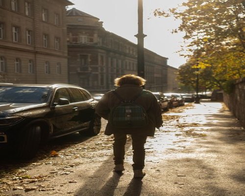 Person walking comfortably on a sunny street in a European city
